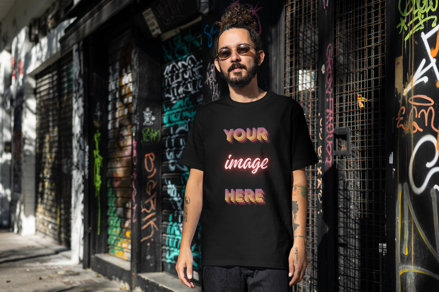 Person wearing a black t-shirt with 'Your image here' text in an urban setting with graffiti.