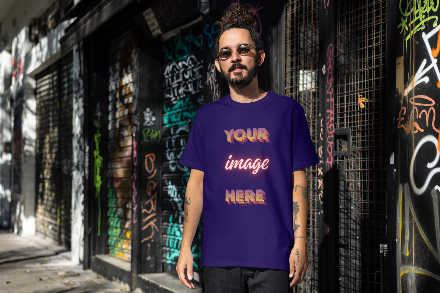 Man wearing a blue t-shirt with 'Your Image Here' text in an urban setting with graffiti.